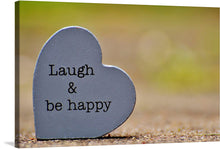  “Laugh & Be Happy” is a captivating piece of artwork that encapsulates the essence of joy and contentment. This print, featuring a heart-shaped slate with the uplifting message engraved upon it, serves as a daily reminder to embrace happiness and laughter. Positioned against a serene backdrop of soft shadows and greenery, the contrast accentuates the simplicity yet profoundness of its message.