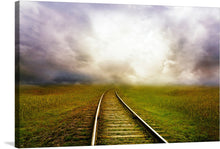   “The Railroad Goes Into The Distance” is a mesmerizing artwork that captures the essence of an enigmatic journey. The print encapsulates a single, narrow railroad track, meticulously detailed, as it meanders into an ethereal mist. Surrounded by wild grass that dances in the gentle breeze, the scene is set against a backdrop of a tumultuous sky painted with hues of grey and white. 