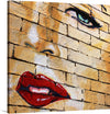 “Woman’s Face Painted On Brick Wall” invites you into a world where art and urban grit collide. This captivating piece masterfully marries the raw, unyielding texture of brick with the soft, ethereal beauty of a woman’s visage. Each stroke is a testament to an artist’s touch that breathes life and emotion into inanimate stone. The eyes, imbued with an otherworldly glow, beckon viewers into a narrative spun from color and imagination, while the luscious red lips whisper tales of passion and mystery.