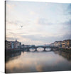 This beautiful photograph captures the iconic Ponte Vecchio bridge in Florence, Italy. The bridge is one of the most popular tourist destinations in the world, and it is known for its unique shops and beautiful views of the Arno River.