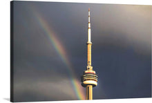  This captivating print captures the iconic tower standing majestically against a dramatic sky, with a radiant rainbow gracing the scene. The contrast between the dark, ominous clouds and the vibrant spectrum of colors from the rainbow creates a visually striking effect. The tower, bathed in natural light, stands as a beacon of architectural splendor.
