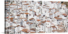  “Casares, Spain” is a beautiful print of the picturesque white-washed houses of Casares, a town in southern Spain. The image is a bird’s eye view of the town’s white-washed houses, tightly packed together with red-tiled roofs. 