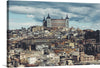 “Toledo, Spain” invites you to immerse yourself in the enchanting allure of this ancient city. Captured by artist Greta Scholderle Moller, this exquisite print transports you to the heart of Toledo, where time stands still. The iconic Alcázar of Toledo stands majestically against a sky that shifts from warm gold to cool blue. 