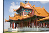 Immerse yourself in the serene beauty of this exquisite print, “Nan Hua Temple in South Africa.” The artwork captures a traditional Chinese pagoda, its vibrant red and green facade adorned with intricate designs, standing majestically against the backdrop of clear skies and an expansive landscape. 