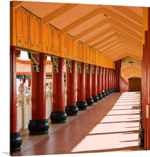  Immerse yourself in the serene elegance of this exquisite print, “Nan Hua Temple in South Africa Part 2.” The artwork captures a traditional corridor adorned with vibrant red pillars and golden embellishments. The intricate shadows cast by the pillars dance gracefully on the sun-kissed floor, creating a captivating pattern that enhances the visual depth of the corridor.