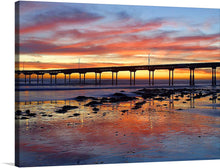  Immerse yourself in the serene beauty of a coastal sunset with this exquisite print. The artwork captures a tranquil scene where the golden hues of the setting sun paint a masterpiece across the sky, reflecting its warm tones onto the gentle waves below. A pier stands as a silent witness to nature’s spectacle, offering viewers a sense of stability amidst the ever-changing tides. 