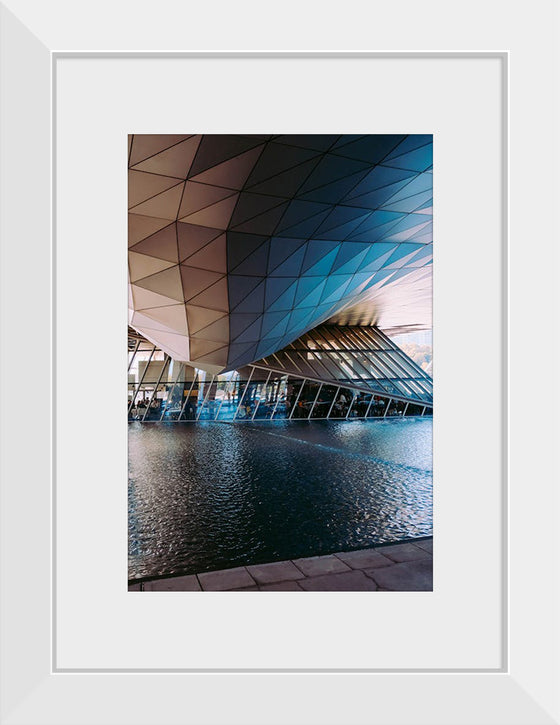 "Low Angle Shot Of A Futuristic Building Design With An Outdoor Pond"