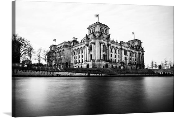 Immerse yourself in the grandeur and elegance of this exquisite print capturing a majestic architectural masterpiece. The artwork, rendered in striking black and white, unveils the intricate details and timeless beauty of a historic building standing proudly by the serene waters. Every line, curve, and stone is a testament to the skilled craftsmanship of an era long past yet preserved in this stunning visual narrative. 