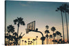 In this captivating image, the sun kisses the Venice Beach basketball court, casting a warm, golden glow on the vibrant blue hues of the ocean. The silhouette of a basketball goal becomes a symbol of determination and grace. The rhythmic waves echo the rhythm of the game, and the salty breeze carries whispers of legendary pick-up games played under this very sky.