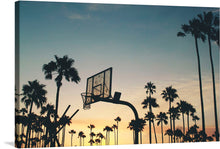  In this captivating image, the sun kisses the Venice Beach basketball court, casting a warm, golden glow on the vibrant blue hues of the ocean. The silhouette of a basketball goal becomes a symbol of determination and grace. The rhythmic waves echo the rhythm of the game, and the salty breeze carries whispers of legendary pick-up games played under this very sky.