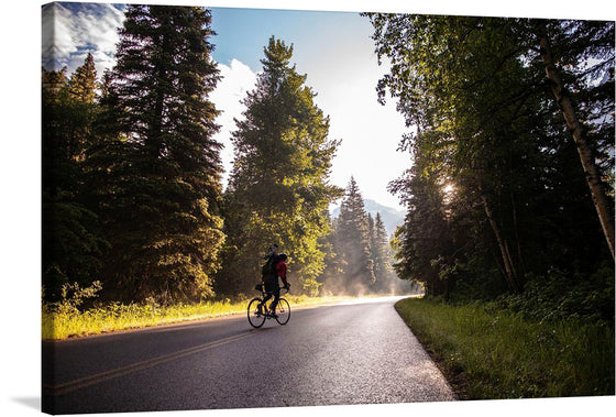 “Biking Going to the Sun Road” Art Print: A Journey of Unity and Exploration  Captured in the golden embrace of sunlight, “Biking Going to the Sun Road” invites you to pedal alongside a lone cyclist on an awe-inspiring adventure. As the wheels turn, the road winds through lush greenery, and mist rises from the asphalt, creating an ethereal atmosphere. The towering trees stand as silent witnesses, their elongated shadows hinting at the passage of time. 