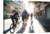 “Biking Buddies Through the City” Art Print: A Journey of Unity and Exploration  Captured in the golden embrace of sunlight, “Biking Buddies Through the City” invites you to pedal alongside four cyclists on their urban adventure. The synchronized motion of their wheels creates a sense of camaraderie, while elongated shadows hint at the passage of time. 