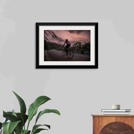 "Male bicycling along a treed road in Ooty"