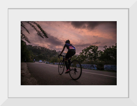 "Male bicycling along a treed road in Ooty"