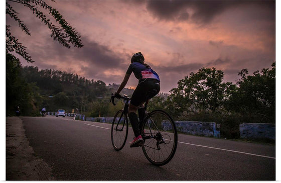 "Male bicycling along a treed road in Ooty"