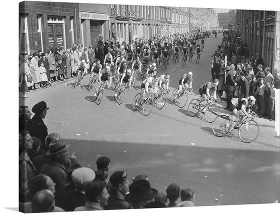 Capture a moment in history with this evocative print, showcasing a spirited bicycle race from an era gone by. The cyclists, clad in the attire of the time, pedal fiercely through a bustling street lined with eager spectators. Every face, every bicycle, and every building tells a story of a moment frozen in time. This artwork is not just a print but an experience of nostalgia and the timeless spirit of competitive racing.