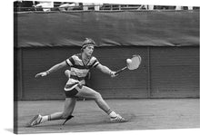  “Tennis, melkhuisje Eric Wilborts in aktie, nr. 26 close” by Marcel Antonisse captures the essence of competitive tennis in a single frame. This black and white photograph freezes a pivotal moment—an athlete lunging forward, racquet poised, ready to strike. The striped outfit adds a classic touch, emphasizing the intensity of the game. 