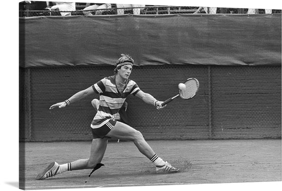 “Tennis, melkhuisje Eric Wilborts in aktie, nr. 26 close” by Marcel Antonisse captures the essence of competitive tennis in a single frame. This black and white photograph freezes a pivotal moment—an athlete lunging forward, racquet poised, ready to strike. The striped outfit adds a classic touch, emphasizing the intensity of the game. 
