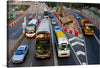 This dynamic photograph captures the frenetic energy of a Hong Kong rush hour commute. Double-decker buses their red paint gleaming in the neon light, snake their way through a maze of towering skyscrapers.