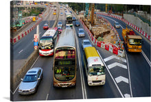  This dynamic photograph captures the frenetic energy of a Hong Kong rush hour commute. Double-decker buses their red paint gleaming in the neon light, snake their way through a maze of towering skyscrapers.