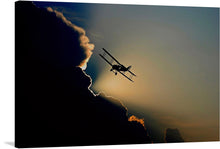  Elevate your space with this captivating print, capturing a moment of serene flight. A biplane, silhouetted against the golden embrace of the setting sun, offers a harmonious blend of vintage charm and natural splendor. The contrasting dark clouds accentuate the aircraft’s graceful lines, inviting viewers into a world where man and nature coexist in beautiful synergy. This artwork is not just a print but an experience, evoking feelings of freedom and tranquility. 