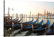   The artwork captures a tranquil morning, where gondolas gently rock on the calm waters, tethered to their posts, awaiting the day’s adventures. The iconic architecture of Venice looms in the background, bathed in the soft glow of dawn.