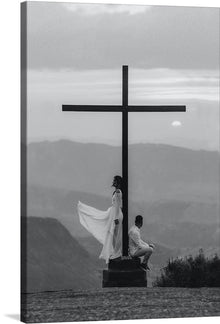  “Man and Woman with Cross” is a captivating piece of art that encapsulates the serene and profound connection between humanity and spirituality. This exquisite black and white print captures two figures in contemplative postures beside a towering cross, set against the backdrop of a tranquil landscape. The ethereal quality of the misty mountains, coupled with the gentle rise of the moon, evokes a sense of peace, reflection, and transcendence.
