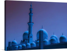  This captivating print captures the ethereal beauty of the Sheikh Zayed Grand Mosque, bathed in a mesmerizing blue hue that accentuates its intricate designs and architectural magnificence. The mosque’s iconic minaret stands tall amidst a series of domes, each adorned with detailed artwork that is both intricate and awe-inspiring. 