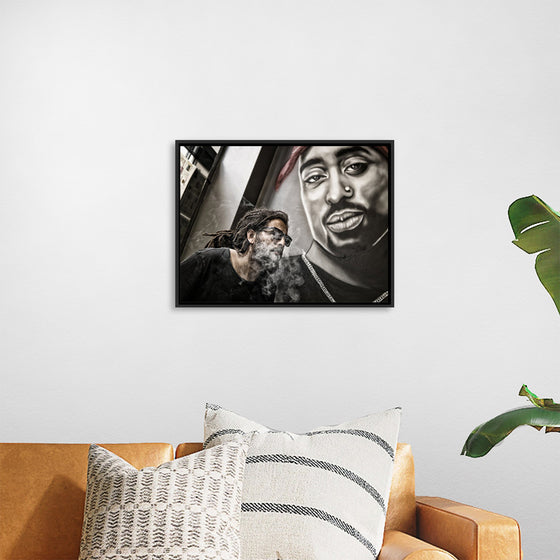 "Man With Dreadlocks and Sunglasses Poses Near Tupac Shakur Portrait"