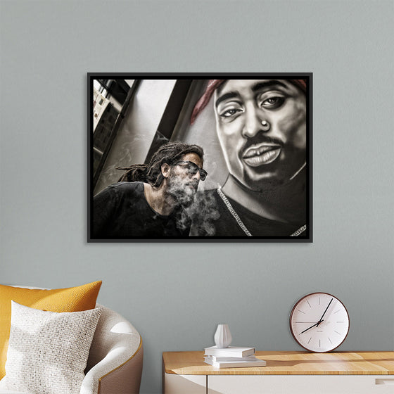 "Man With Dreadlocks and Sunglasses Poses Near Tupac Shakur Portrait"