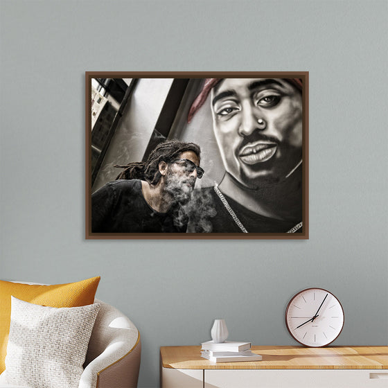 "Man With Dreadlocks and Sunglasses Poses Near Tupac Shakur Portrait"