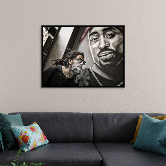 "Man With Dreadlocks and Sunglasses Poses Near Tupac Shakur Portrait"