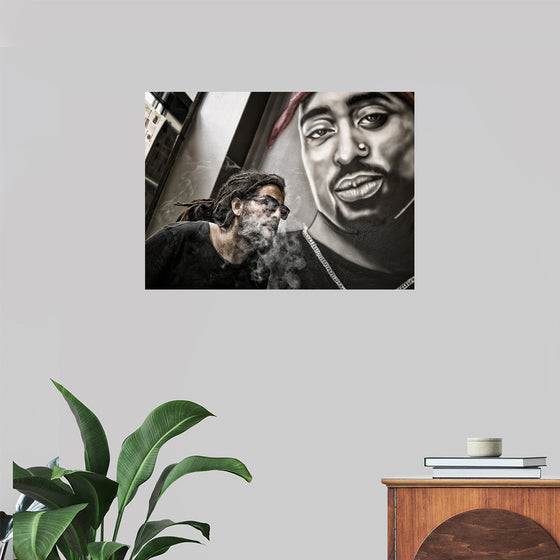 "Man With Dreadlocks and Sunglasses Poses Near Tupac Shakur Portrait"