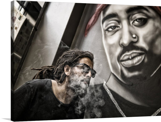 Dive into the enigmatic allure of this captivating artwork, now available as a limited edition print. The piece captures a moment frozen in time, where smoke dances gracefully around a portrait of Tupac Shakur, evoking a sense of mystery and introspection. The monochromatic tones are punctuated by the stark contrast of light and shadow, weaving a narrative that invites viewers to explore the depths of human emotion and experience.