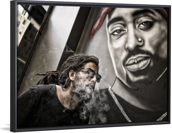 "Man With Dreadlocks and Sunglasses Poses Near Tupac Shakur Portrait"