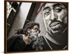 "Man With Dreadlocks and Sunglasses Poses Near Tupac Shakur Portrait"