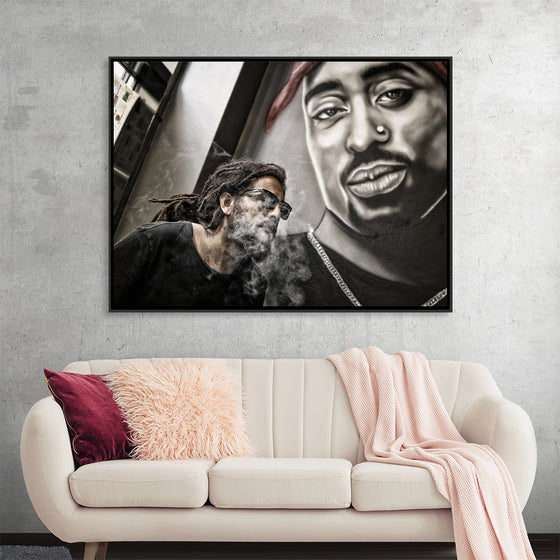 "Man With Dreadlocks and Sunglasses Poses Near Tupac Shakur Portrait"