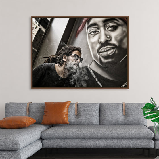 "Man With Dreadlocks and Sunglasses Poses Near Tupac Shakur Portrait"