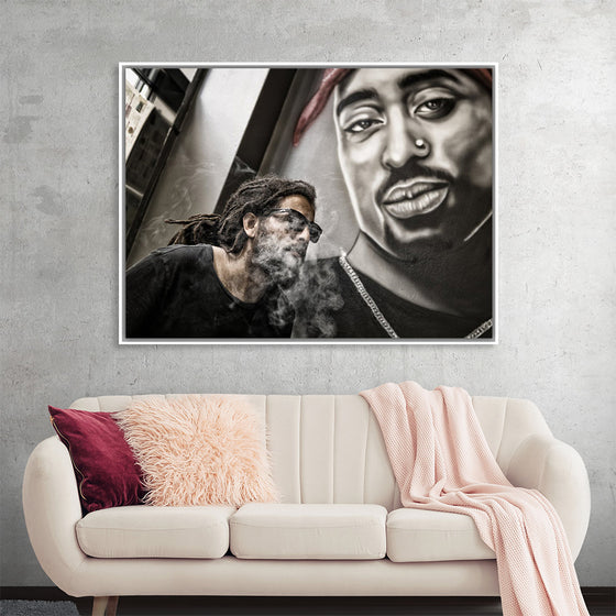 "Man With Dreadlocks and Sunglasses Poses Near Tupac Shakur Portrait"