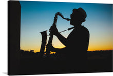  This artwork, titled “Silhouette of a Man Playing Saxophone during Sunset,” captures a serene and soulful moment. The silhouette of a man, engrossed in the melodies of his saxophone, stands against the gentle hues of the setting sun. The image exudes a sense of calmness and musical harmony, intertwining the visual and auditory senses. The intricate details of the saxophone, even in silhouette, highlight its curves and keys, adding depth to the artwork. 