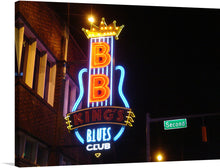  This captivating print features a close-up of BB King’s Blues Club sign, an iconic destination paying tribute to the King of the Blues, B.B. King. The neon lights in blue, red, and yellow illuminate the night sky, creating an electric atmosphere. 