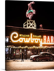  Step into the world of the Wild West with this captivating print of the iconic Million Dollar Cowboy Bar. Illuminated under the starry night sky, the bar’s radiant neon signs cast a warm, inviting glow that beckons patrons to enter and experience an evening of old-world charm. The intricate neon artwork showcases a lively cowboy silhouette, adding a touch of nostalgia and authenticity. 