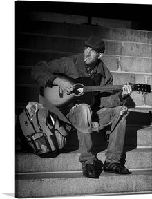  The “Man Guitar Player” print is a stunning piece of art that captures the raw essence of musical passion. The monochromatic tones paint a narrative of solitude and introspection, inviting viewers into a world where music is both an escape and a companion. The image features an individual playing guitar on stone steps, with their face obscured for privacy. 