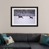 "Two white-tailed deer run through the snow"