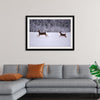 "Two white-tailed deer run through the snow"