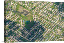  This beautiful print of a suburban neighborhood is a perfect addition to any home. The photo is taken from a high angle, looking down on the houses and streets. The houses are arranged in a grid-like pattern, with streets and sidewalks in between. There is a small lake in the top left corner of the photo. 