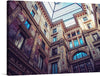 This print is a beautiful photograph of the interior of a grand Italian courtyard. The intricate details and stunning architecture make this a perfect piece for any art lover. The courtyard is surrounded by ornate walls and arches with intricate details. The walls are decorated with frescoes and sculptures. The courtyard has a glass roof that allows natural light to flood in. The image is taken from a low angle, looking up at the walls and roof. 