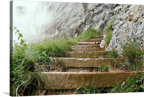 “Outside Stairway” is a captivating print that captures the essence of a rustic wooden staircase nestled against a rugged mountainside. The mist from the adjacent waterfall dances around the scene, breathing life and movement into this still capture. Each step, weathered and rich with history, invites you into a world where nature and humanity converge. 