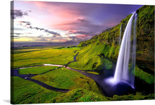  A majestic waterfall cascades gracefully down a lush green cliff, its mist kissing the tranquil pool below. The verdant landscape stretches endlessly, adorned with vibrant hues of green that signify life’s unyielding bloom. As the sun sets, it paints the sky with mesmerizing strokes of pinks and purples - a testament to nature’s masterpiece. 