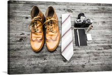  The artwork captures the essence of a gentleman’s ensemble, meticulously laid out and ready to don. A pair of well-worn leather shoes, rich in character and stories untold, sits beside a crisply folded striped tie - an emblem of sophistication. Adjacent, the timeless charm of a vintage camera evokes nostalgia, while a sleek notebook awaits the day’s musings. 